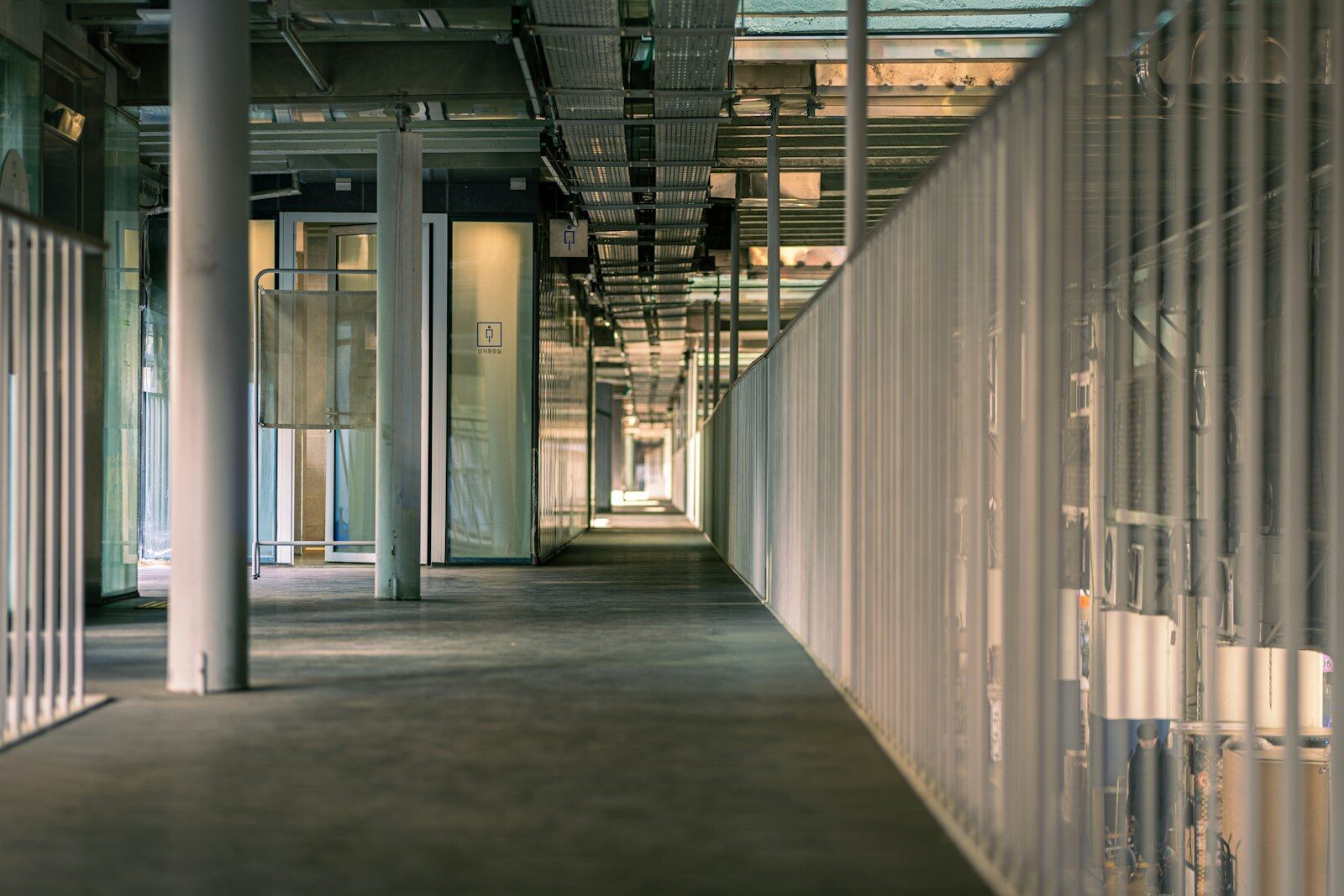 a long hallway with white walls and metal railings